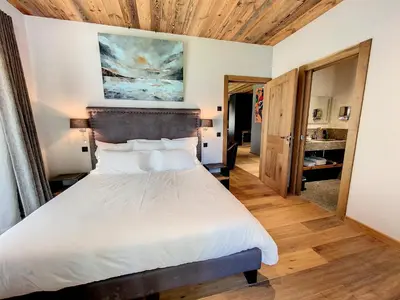 a bedroom with a bed and a painting on the wall at LES ALPES III in Chamonix-Mont-Blanc