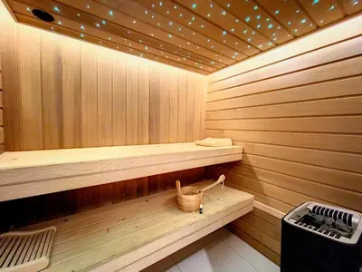 a sauna with a bench and a bucket in it at LES ALPES III in Chamonix-Mont-Blanc