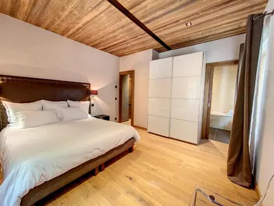 a bedroom with a large bed and a wooden ceiling at LES ALPES III in Chamonix-Mont-Blanc