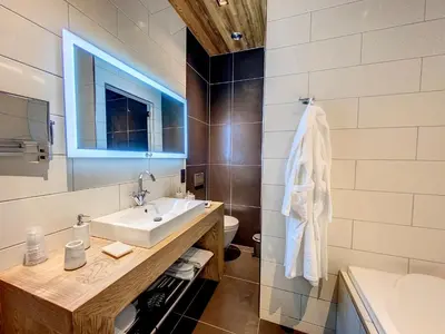a bathroom with a sink and a toilet and a mirror at LES ALPES III in Chamonix-Mont-Blanc