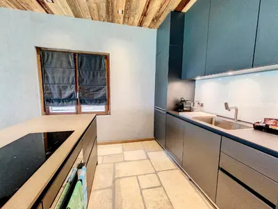 a kitchen with blue cabinets and a sink and a window at LES ALPES III in Chamonix-Mont-Blanc