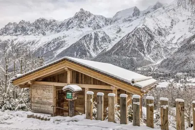 a cabin in the mountains with snow on the roof at Chalet 3 étoiles pour 4 pers avec vue imprenable sur la vallée de Chamonix in Les Houches
