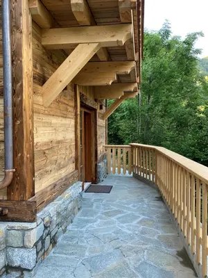 a wooden porch of a log cabin with a wooden walkway at Chalet 3 étoiles pour 4 pers avec vue imprenable sur la vallée de Chamonix in Les Houches