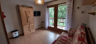 a living room with a couch and a large window at Un havre de paix aux pieds des chemins de montagne in Les Contamines-Montjoie