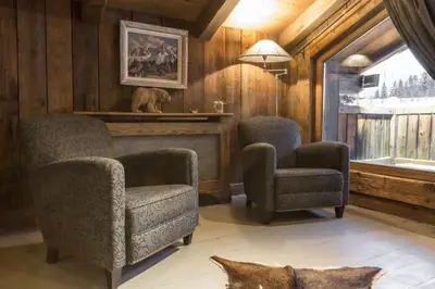 a living room with two chairs and a fireplace at Chalet l'Ourson, avec jacuzzi, sauna, services hôteliers in Chamonix-Mont-Blanc