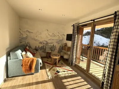 a living room with a mountain mural on the wall at Marmots Clan Megève in Megève