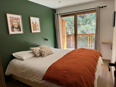 a bedroom with green walls and a bed with a window at Marmots Clan Megève in Megève