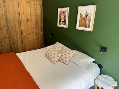 a green bedroom with a bed with two pillows at Marmots Clan Megève in Megève