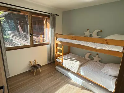 a bedroom with two bunk beds and a window at Marmots Clan Megève in Megève