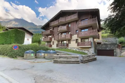 a building with two trash cans in front of it at Le Grand Tetras - Beside Lake Chavants, TMB staring point & Hikes in Les Houches