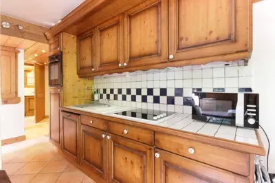 a kitchen with wooden cabinets and a sink at Le Grand Tetras - Beside Lake Chavants, TMB staring point & Hikes in Les Houches