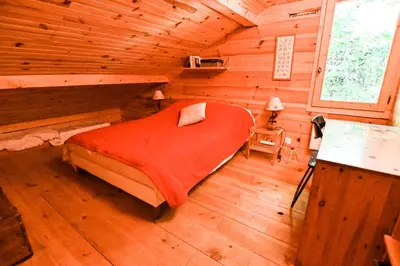 a bedroom with a bed in a wooden cabin at Nice Peaceful Cottage With Garden And Balcony in Saint-Gervais-les-Bains