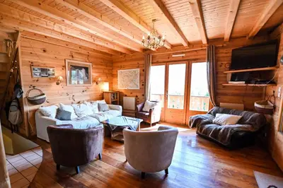 a living room with couches and a television in a log cabin at Nice Peaceful Cottage With Garden And Balcony in Saint-Gervais-les-Bains