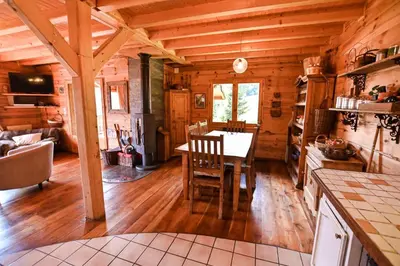 a kitchen and dining room with a table in a cabin at Nice Peaceful Cottage With Garden And Balcony in Saint-Gervais-les-Bains