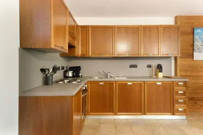 a kitchen with wooden cabinets and a sink at Les Granges des Bossons in Chamonix-Mont-Blanc