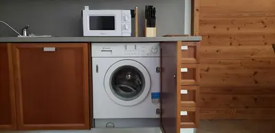 a washing machine with a microwave on top of it at Les Granges des Bossons in Chamonix-Mont-Blanc