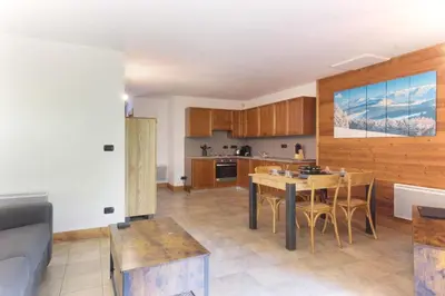 a kitchen and living room with a table and chairs at Les Granges des Bossons in Chamonix-Mont-Blanc