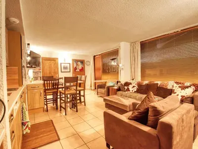 a living room with a couch and a table and a kitchen at Appartement de 60 m² pour 6 personnes, pied des pistes - FR-1-642-71 in Morillon