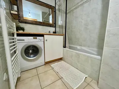 a small bathroom with a washing machine and a tub at Appartement chaleureux avec balcon près du centre - FR-1-624-112 in Samoëns