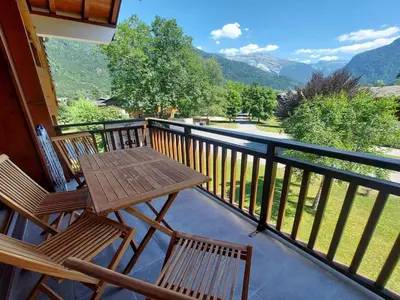 a table and chairs on a balcony with a view at Appartement chaleureux avec balcon près du centre - FR-1-624-112 in Samoëns
