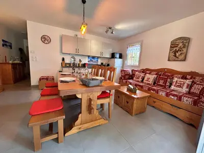 a living room with a table and a couch at Appartement neuf avec balcon et navette pour le ski - FR-1-624-113 in Samoëns