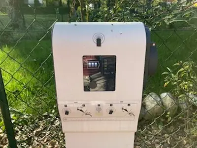 a white parking meter sitting next to a fence at Appartement neuf avec balcon et navette pour le ski - FR-1-624-113 in Samoëns