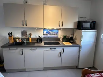 a kitchen with white cabinets and a white refrigerator at Appartement neuf avec balcon et navette pour le ski - FR-1-624-113 in Samoëns