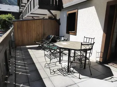 a patio with a table and chairs on a balcony at Résidence Palmes D'or - Palmes d'Or B109 MAE-5504 in Les Contamines-Montjoie