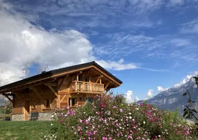 a log cabin with chairs and a balcony at Chalet récent vue panoramique sur le MONT-BLANC in Combloux