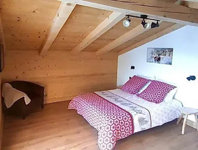 a bedroom with a table and a bed in a room at Chalet récent vue panoramique sur le MONT-BLANC in Combloux