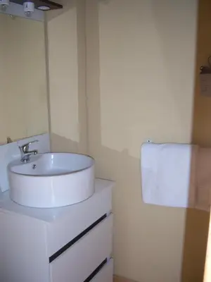 a bathroom with a white sink and a towel at Hotel Edelweiss in Magland