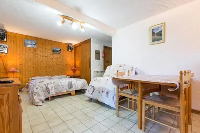 a room with two beds and a table in it at Chalet spacieux à Saint-Gervais-les-Bains avec vue montagne in Saint-Gervais-les-Bains