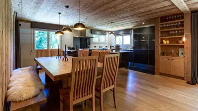 a kitchen and dining room with a wooden table and chairs at Chalet Birdie in Les Houches