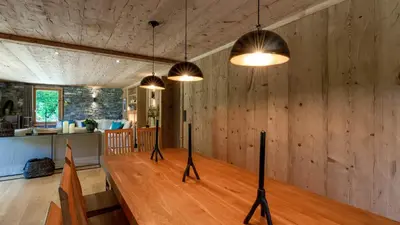 a dining room with a wooden table and some lights at Chalet Birdie in Les Houches