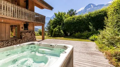 a hot tub on a deck next to a building at Chalet Birdie in Les Houches