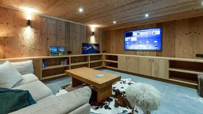 a living room with a couch and a tv at Chalet Birdie in Les Houches