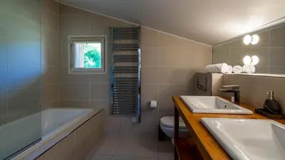 a bathroom with a tub and a sink and a toilet at Chalet Birdie in Les Houches