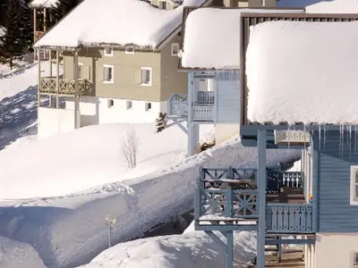 a house covered in snow next to a building at Chalet lumineux · Sauna privatif · Garage · 12 personnes - FR-1-425-119 in Arâches-la-Frasse