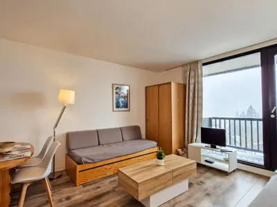 a living room with a bed and a tv at Studio lumineux proche des pistes avec balcon - FR-1-425-169 in Arâches-la-Frasse