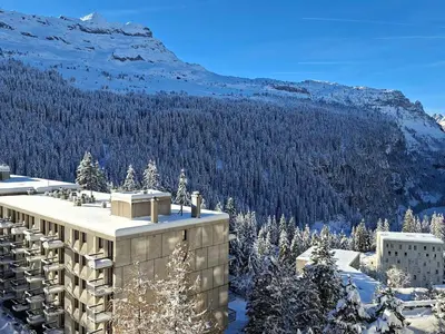 a building in the snow with a mountain in the background at Studio lumineux proche des pistes avec balcon - FR-1-425-169 in Arâches-la-Frasse
