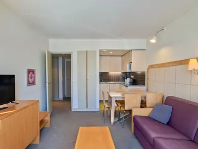 a living room with a purple couch and a kitchen at Appartement lumineux 2 pièces, proche des pistes avec balcon - FR-1-425-175 in Arâches-la-Frasse