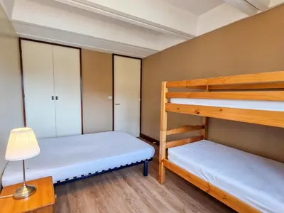 two bunk beds in a room with a lamp at Appartement rénové 2 pièces pour 6, balcon proche pistes et commerces - FR-1-425-158 in Arâches-la-Frasse