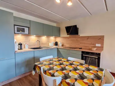 a kitchen with a table and chairs in a room at Appartement rénové 2 pièces pour 6, balcon proche pistes et commerces - FR-1-425-158 in Arâches-la-Frasse