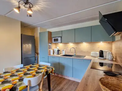 a kitchen with blue cabinets and a table with chairs at Appartement rénové 2 pièces pour 6, balcon proche pistes et commerces - FR-1-425-158 in Arâches-la-Frasse