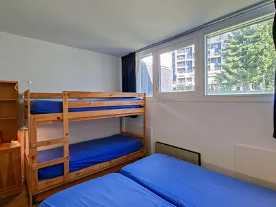 a bedroom with two bunk beds and a window at Appartement confortable au pied des pistes avec Wifi gratuit - FR-1-425-137 in Arâches-la-Frasse