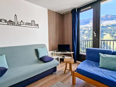 a living room with a couch and a large window at Appartement confortable au pied des pistes avec Wifi gratuit - FR-1-425-137 in Arâches-la-Frasse