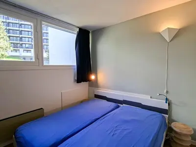a bedroom with a blue bed and a window at Appartement confortable au pied des pistes avec Wifi gratuit - FR-1-425-137 in Arâches-la-Frasse