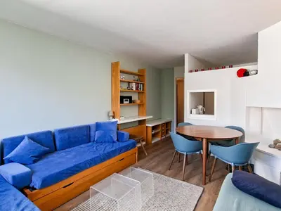 a living room with a blue couch and a table at Appartement confortable au pied des pistes avec Wifi gratuit - FR-1-425-137 in Arâches-la-Frasse