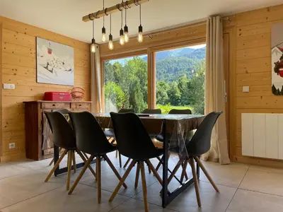a dining room with a table and chairs and a large window at Chalet spacieux, proche des commerces, animaux admis ! - FR-1-624-118 in Samoëns