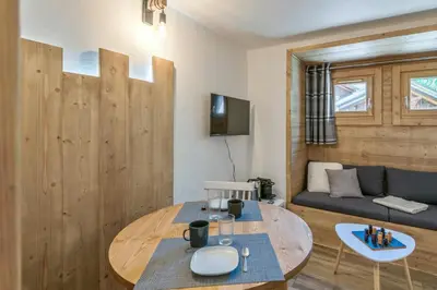 a living room with a table and a couch at Studio Loup - L'Igloo - Welkeys in Combloux